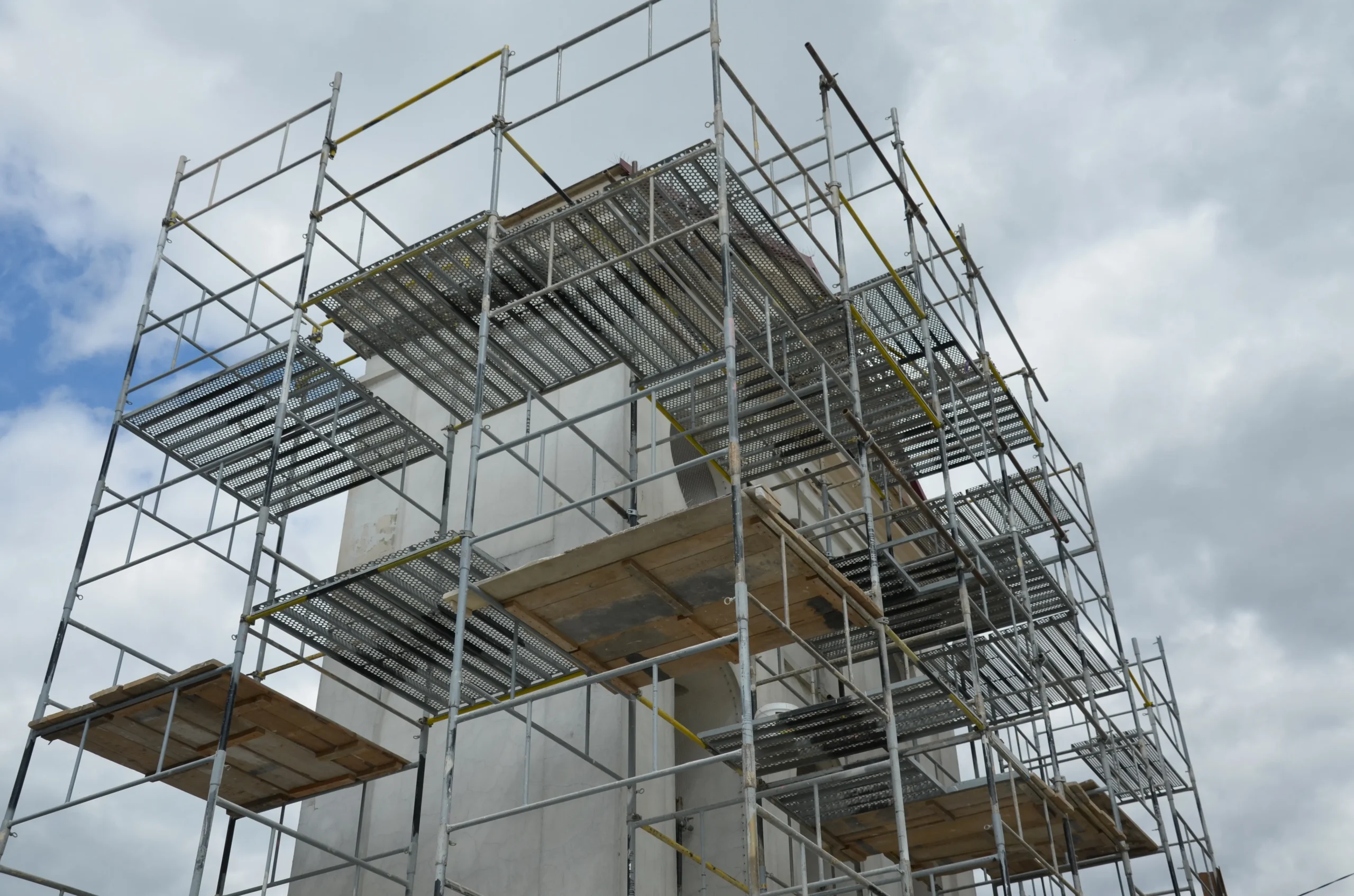 Monter montujący lekkie rusztowanie warszawskie na placu budowy